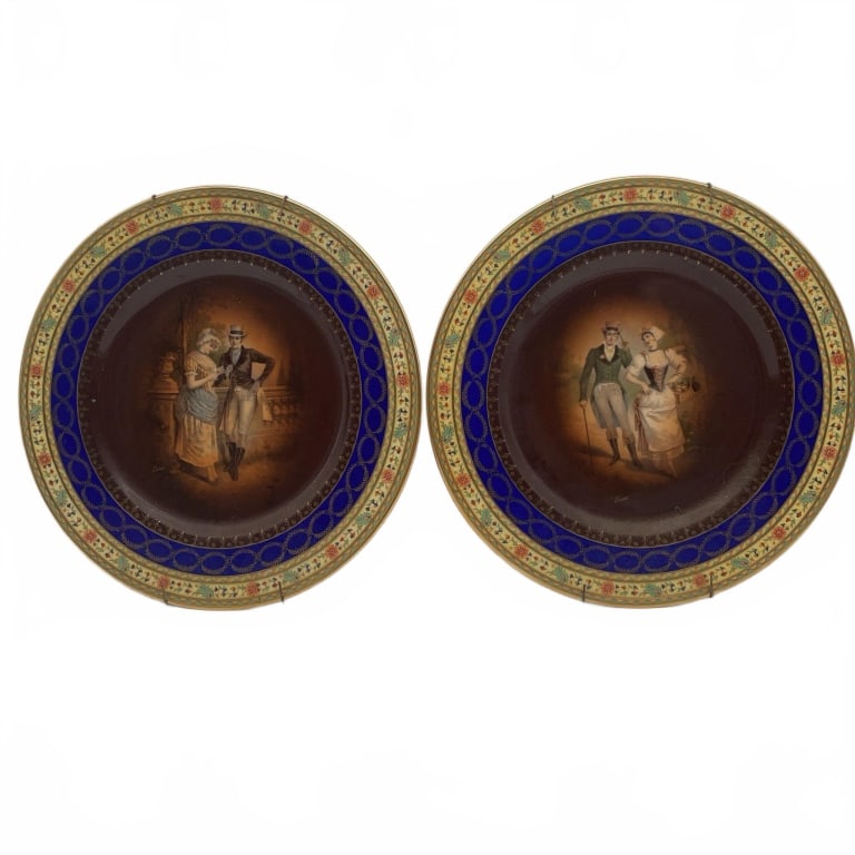 Hand-Painted Decorative Porcelain Plates: Two porcelain plates featuring hand-painted scenes of couples in period attire. Each plate measures approximately 10 inches in diameter. The plates have cobalt blue borders with gold and floral decora