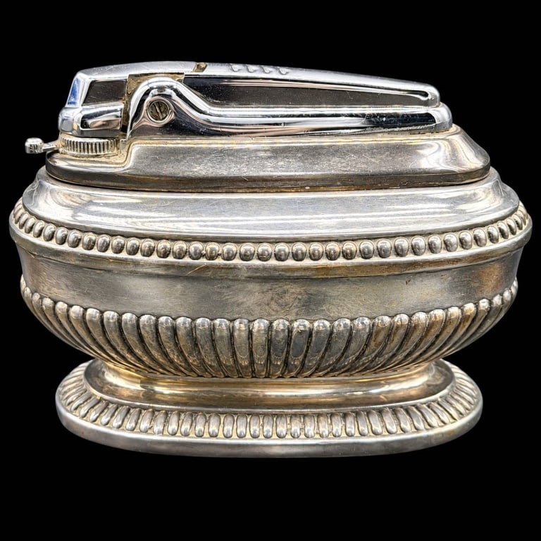 VICTORIAN OVAL PEDESTAL TABLE LIGHTER 2.5": Decorative vintage table lighter featuring an oval silver-tone metal body with beaded borders, a fluted lower band and a matching pedestal foot. Removable lighter insert features a polished lever mech