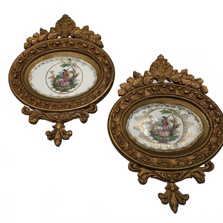 Ornate Gilt Framed Porcelain Plaques 19": Decorative plaques featuring hand-painted porcelain inserts depicting classical figures in garden scenes. Each plaque is set in an elaborate gilt frame with floral and scroll motifs. Approximate size 