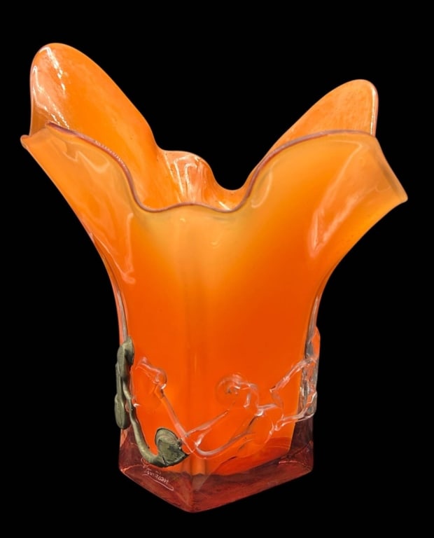 SIGNED ORANGE ART GLASS FIGURAL VASE 14": Striking signed studio art glass vase featuring a vivid translucent orange body with a sculptural free-form flared and ruffled rim. The lower portion is embellished with applied clear glass figures ac