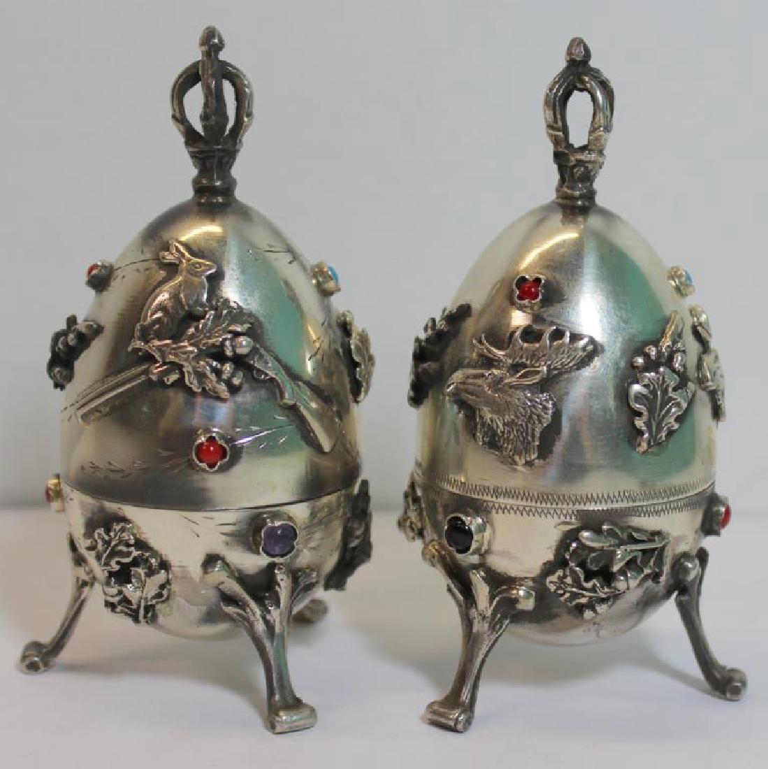 SILVER. Near Pair of Russian Silver Footed Hunt: Eggs. Includes a mid 19th C Russian silver footed egg with applied foliate and rabbit on rifle motif that opens to reveal a standing rabbit. Accompanied by second 19th C Russian silver footed egg with