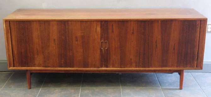 Midcentury Rosewood Tambour Sideboard.: Designed by Arne Vodder for Sibast. Labeled Sibast Furniture and with Danish control button label. Finished rosewood to all sides with long tambour door front and interior drawers and shelves. From a