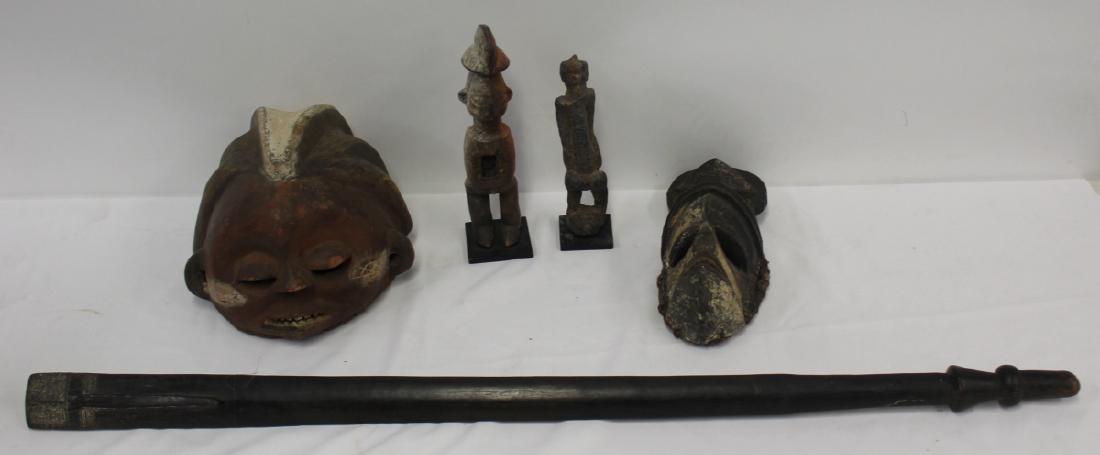 Lot of 5 Antique African Wood Sculptures.: To include 2 masks 10" x 7 1/2H and 4 1/2" x 12 1/2" h, 2 figures 9 1/2" h and 10 1/2" h and a carved cane? 41" H. From a Westchester estate. - Dimensions: See descriptio