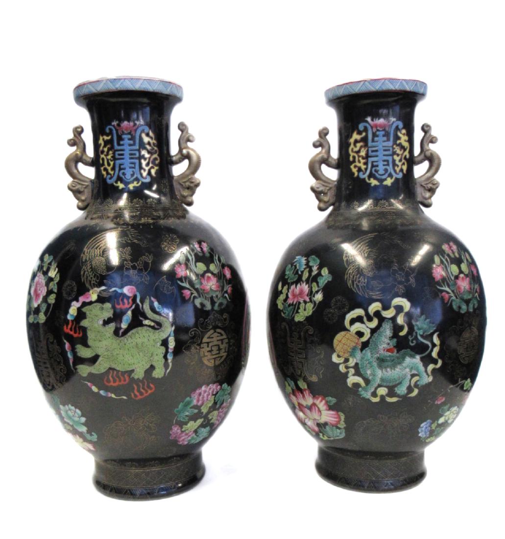 Pair of Famille Noir Vases with Qianlong Mark.: With enameled buddhist lions and gilt phoenixes, each flanked by gilt dragon-form handles. The undersides with apocryphal six character Qianlong mark. From a 5th Avenue, NYC estate. - Dimensions: 15" 