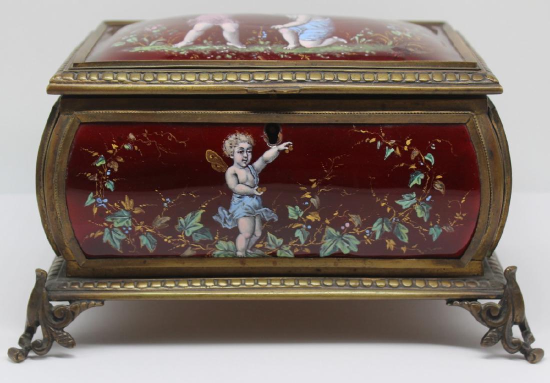 Enamel Decorated Jewelry Casket Box.: Rich ruby red panels of enamel decoration with scenes of children and putti amongst flora and foliate. With Gothic style feet. From a Mt Kisco, NY estate. Dimensions: 8" w x 5.75" d x 4.5&qu