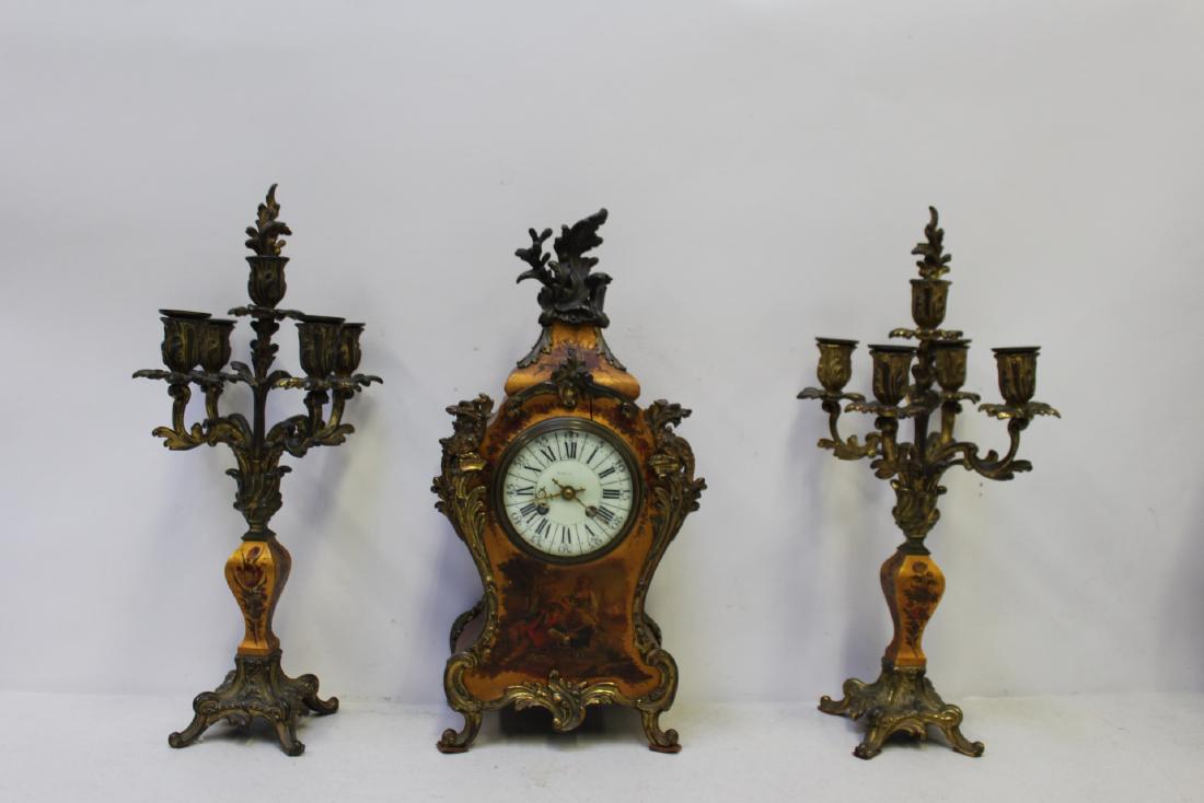 Tiffany & Co Louis XV Style Paint Decorated And: Bronze Mounted Clock Garniture Set. Good quality bronzes and nicely painted . From a Long Island estate. - Dimensions: 17" x 17.5" x 4"D candle 17" H x 9"