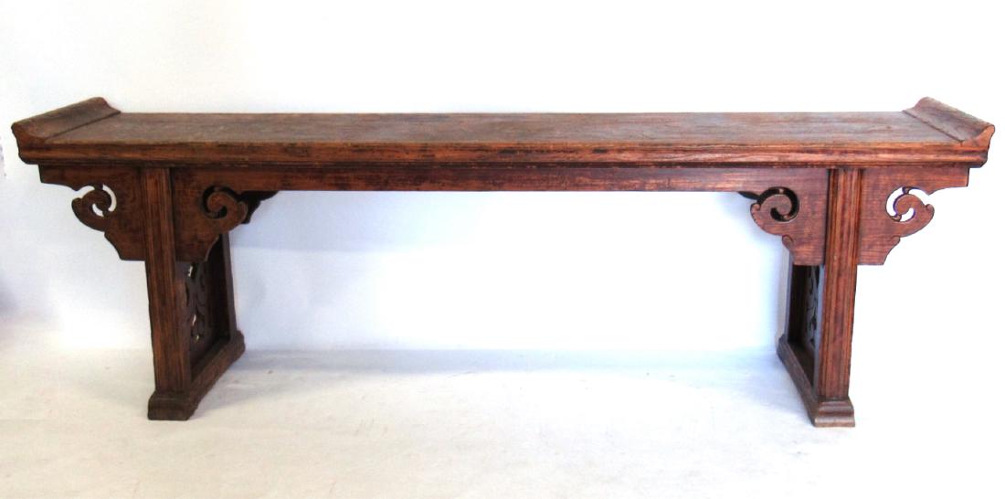 Chinese Hardwood Altar Table.: 20th century. Rectangular top with everted edges over trestle legs with pierced floral designs. From a Chestnut Ridge, NY estate. - Dimensions: 29" h x 88" w x 16" d.