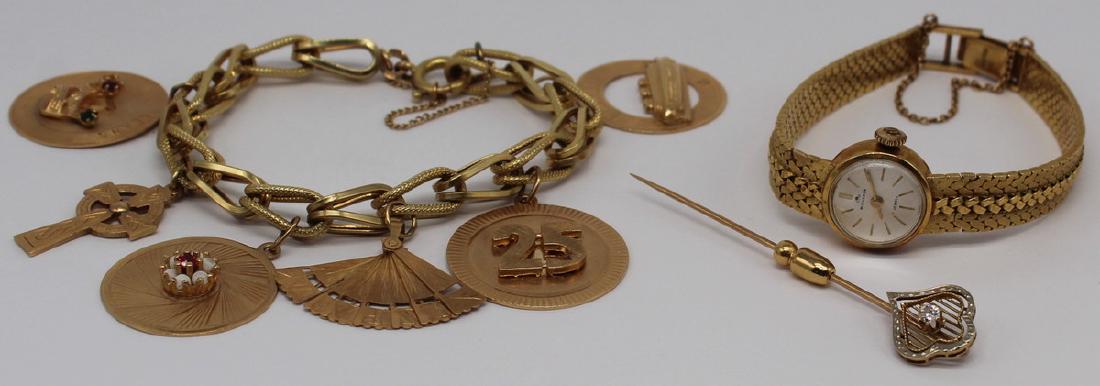 JEWELRY. Misc. Gold Jewelry Grouping.: Includes a ladies' Bucherer 18kt gold wrist watch - 17 jewels movement; a 14kt yellow gold charm bracelet with (6) various 14kt gold charms; and a 14kt yellow gold stickpin with a central Old European