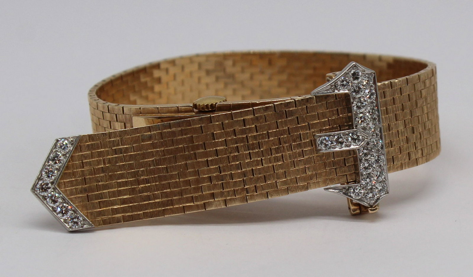 JEWELRY. J.E. Caldwell 14kt Gold and Diamond Watch: Bracelet. Vintage 14kt yellow gold jarretiere style bracelet with hidden J.E. Caldwell watch face. Diamond accents to buckle portion of watch bracelet. With a Concord Watch Co. movement, 17 jewels. To