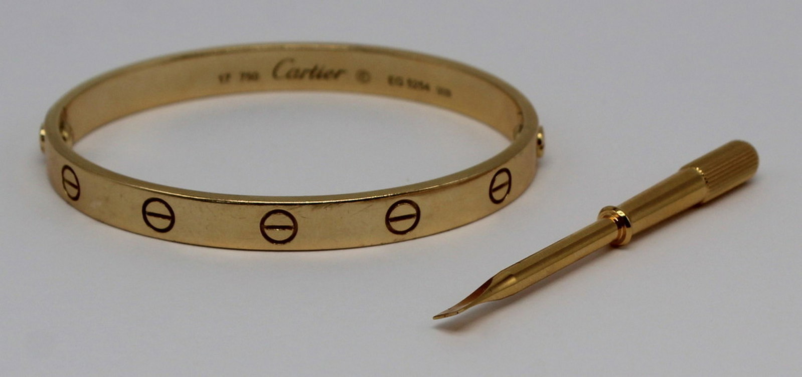 JEWELRY. Cartier 18kt Gold Love Bracelet.: Cartier 18kt yellow gold Love bracelet. Stamped to interior of bracelet, "17 750 Cartier © EG 5254", with an additional stamp of, "1TO" with a star in a rectangular frame. Acc