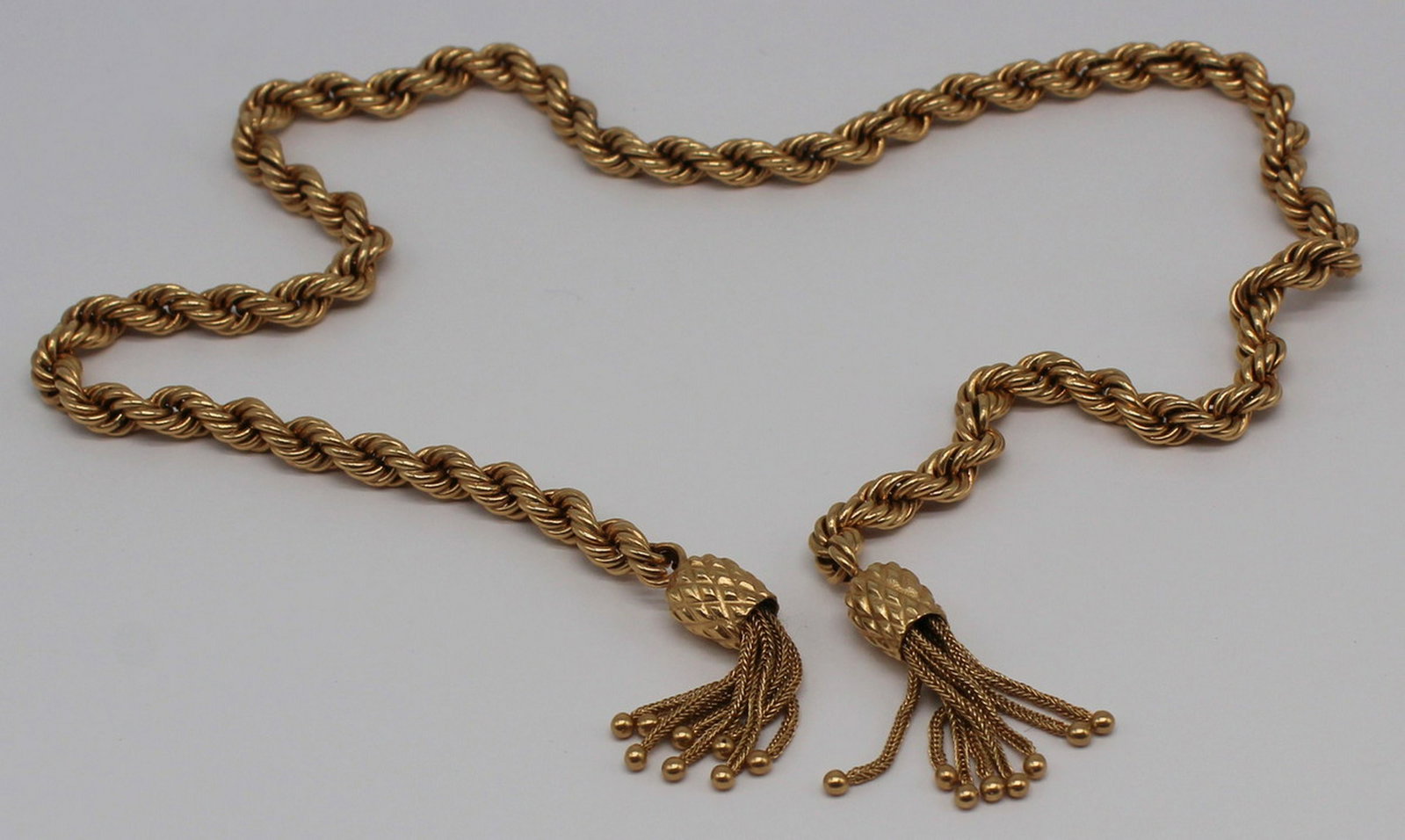 JEWELRY. 14kt Gold Chain with Tassels.: 14kt yellow gold rope twist chain terminating in two pineapple form beads with tassels. Apparently unmarked. Total approx. weight is 21.5 dwt. From a Merrick, NY estate. Dimensions: chain measures app