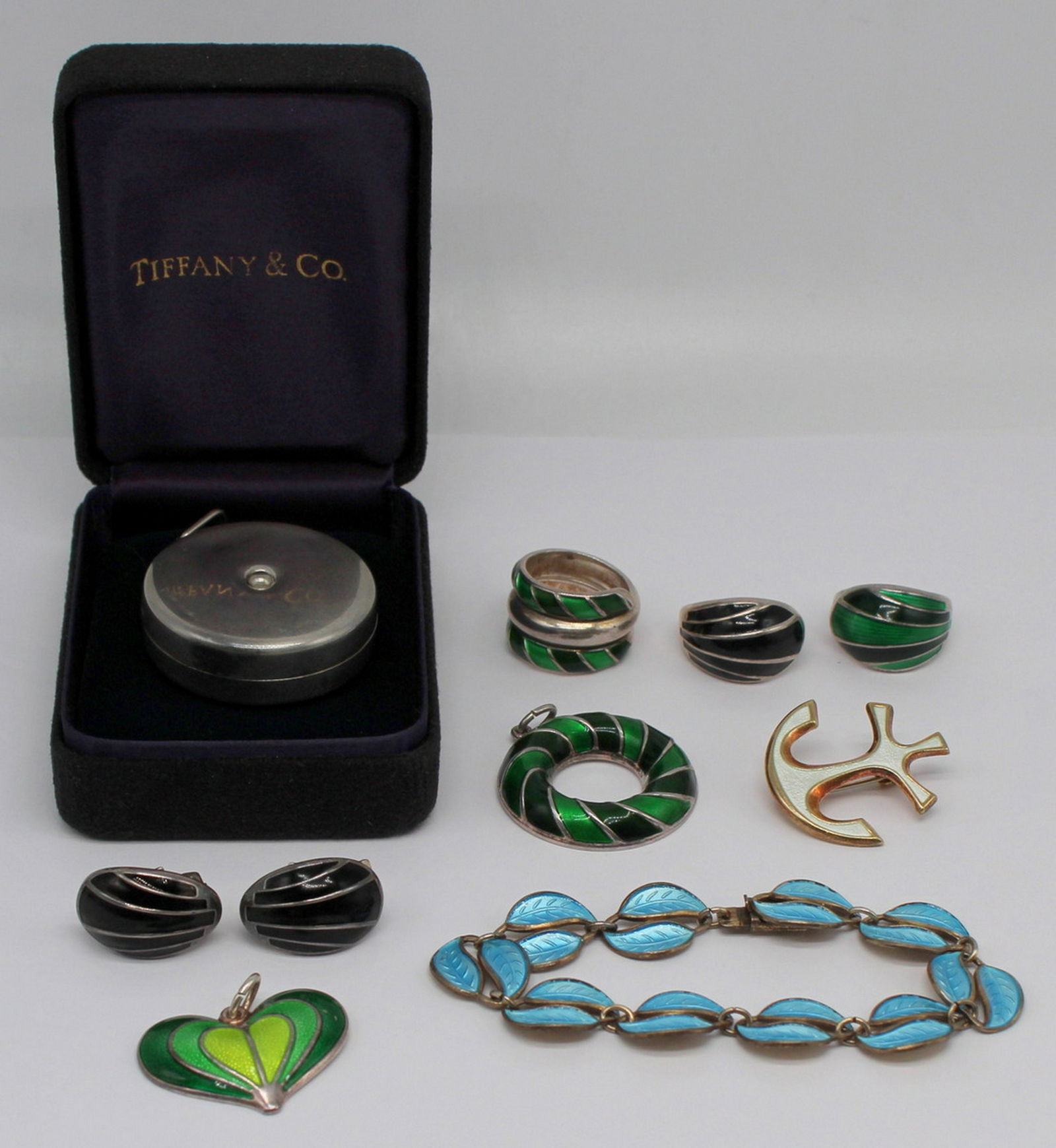 STERLING. Grouping of David Andersen and T&Co.: Includes a Tiffany & Co. sterling tape measurer with original hinged box, lidded box, and dust jacket; a pair of David Andersen sterling ear clips with black enamel decoration and matched David An