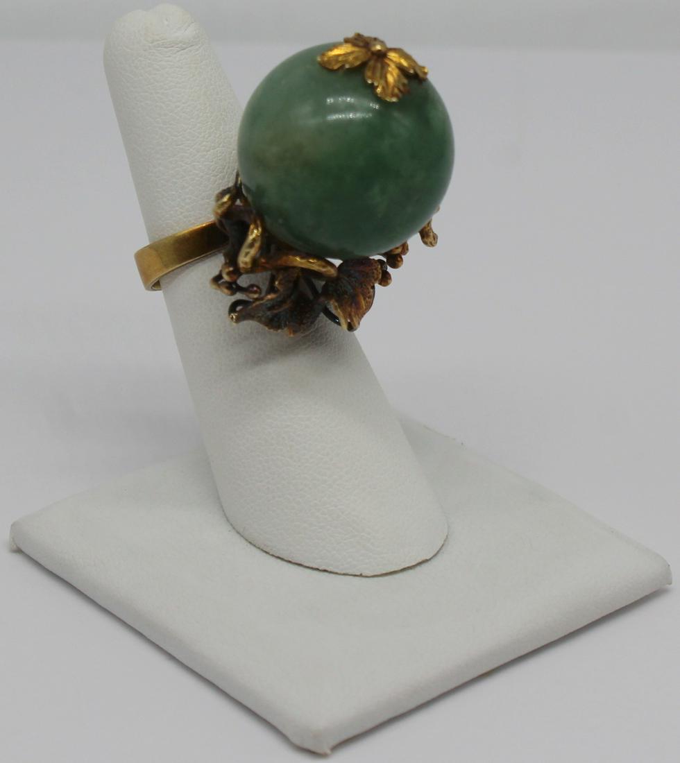 JEWELRY. Jade and 14kt Gold Cocktail Ring.: 14kt yellow gold cocktail ring with large globe form carved jade with applied foliate form details and leaf form "cap" to globe. Stamped, "14k 585" to interior of band. Ring size -