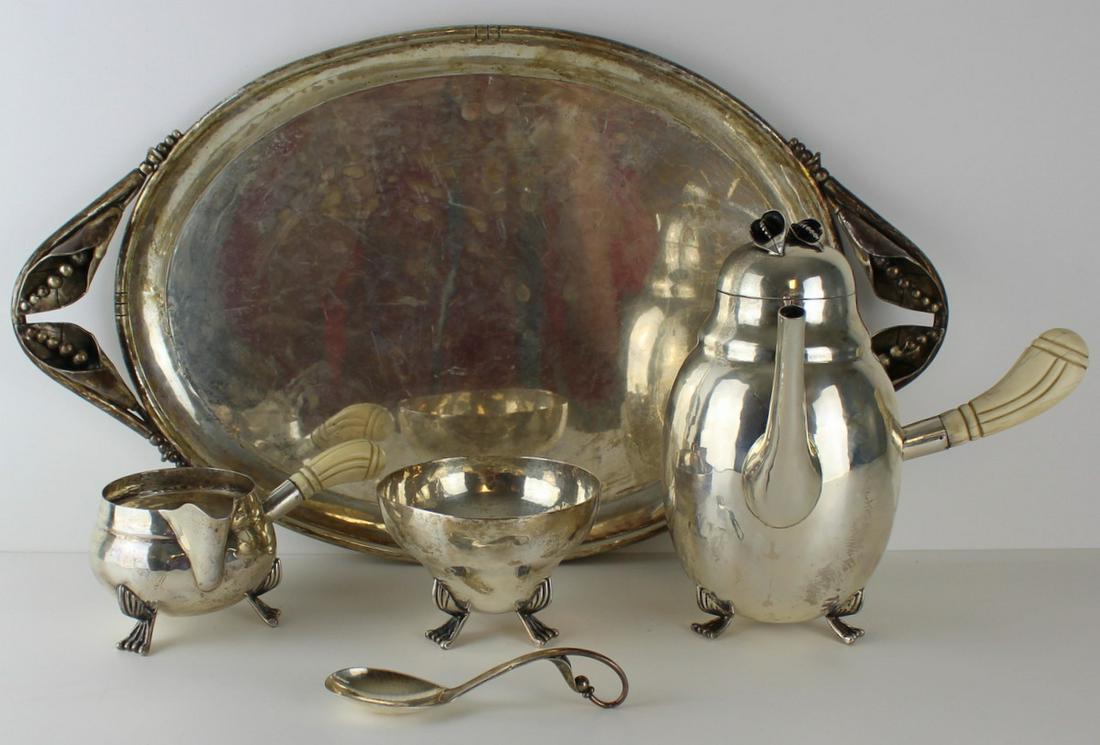 STERLING. Attr. DeMatteo 4 Pc Sterling Tea Service: Four piece sterling tea service attributed to William G. DeMatteo comprised of a teapot, creamer, sugar, and serving tray with handles. All lidded items with foliate finials, foliate handles to servin