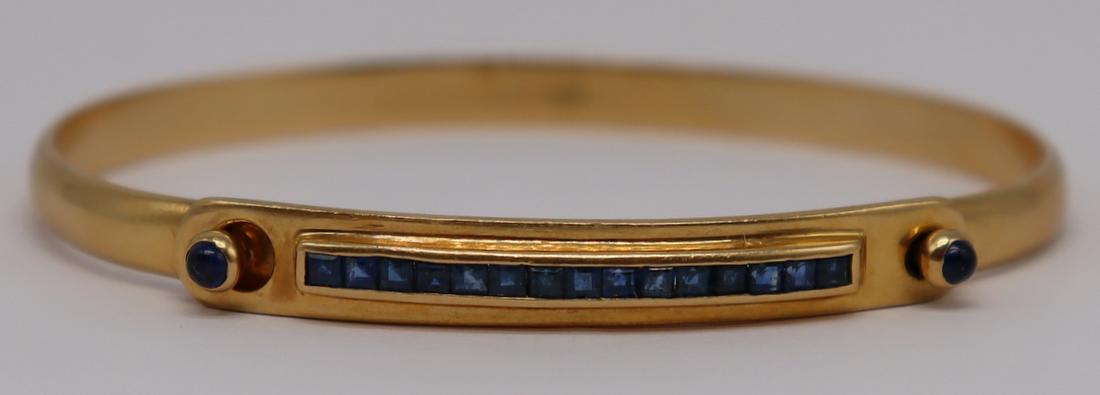JEWELRY. Cartier 18kt Gold and Sapphire Bracelet.: Cartier 18kt yellow gold bracelet with central panel inlaid with a row of (15) channel set sapphires and flanked by (2) sapphire cabochons. Channel set sapphires measure approx. 1.5mm x 1.5mm; sapphir