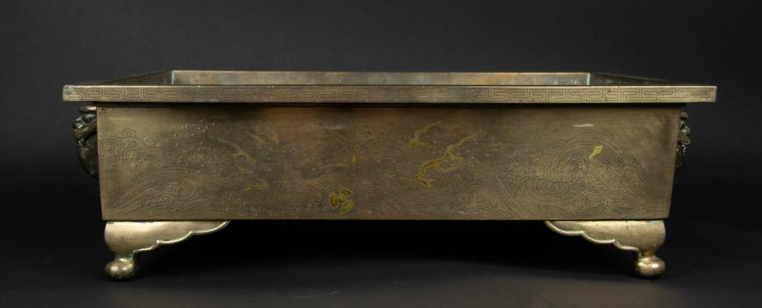 A Massive Meiji Inlaid Planter.: Japanese. Of rectangular form, likely for a bonsai tree, decorated with inlaid silver thunder scrolls to lip, flanked by two lion handles, and inlaid with a phoenix to one side and a dragon clutching 