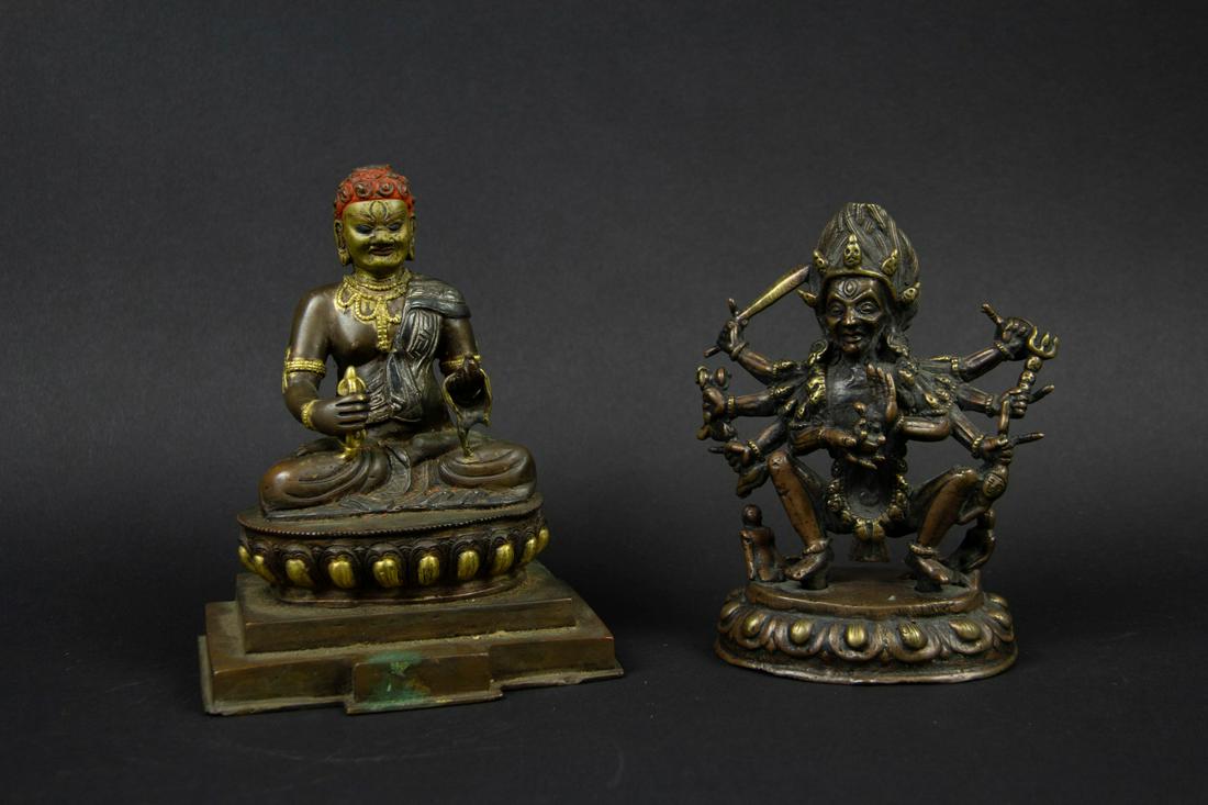 Two Bronze Figures of Kali and Acala.: The figure of Kali Nepalese, the figure of Acala likely Sino-Tibetan. Kali depicted wearing a garland of skulls and holding various implements, squatting above two small human figures. Acala adorned i