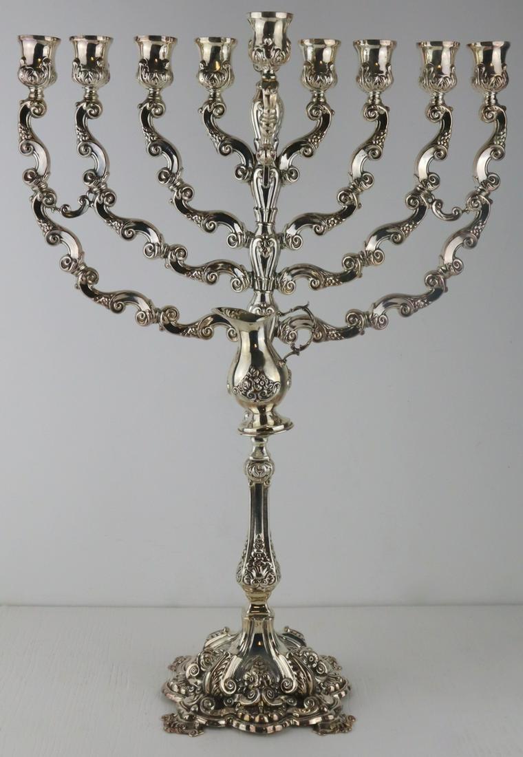 STERLING. Monumental Sterling Menorah.: Monumental sterling menorah with shamash and oil jug. Accompanied by a custom Lucite case with mirrored backing. Stamped, "ST925". Total approx. weight of menorah is 30.62 troy oz. From a Lo