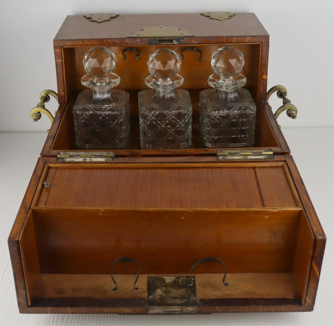 STERLING. Antique English Mappin & Webb Tantalus.: Includes a Mappin & Webb tantalus with (3) central fitted surrounds which hold (2) cut glass decanters with faceted stoppers; flanked by (6) circular inserts that house (2) sterling underplates - 