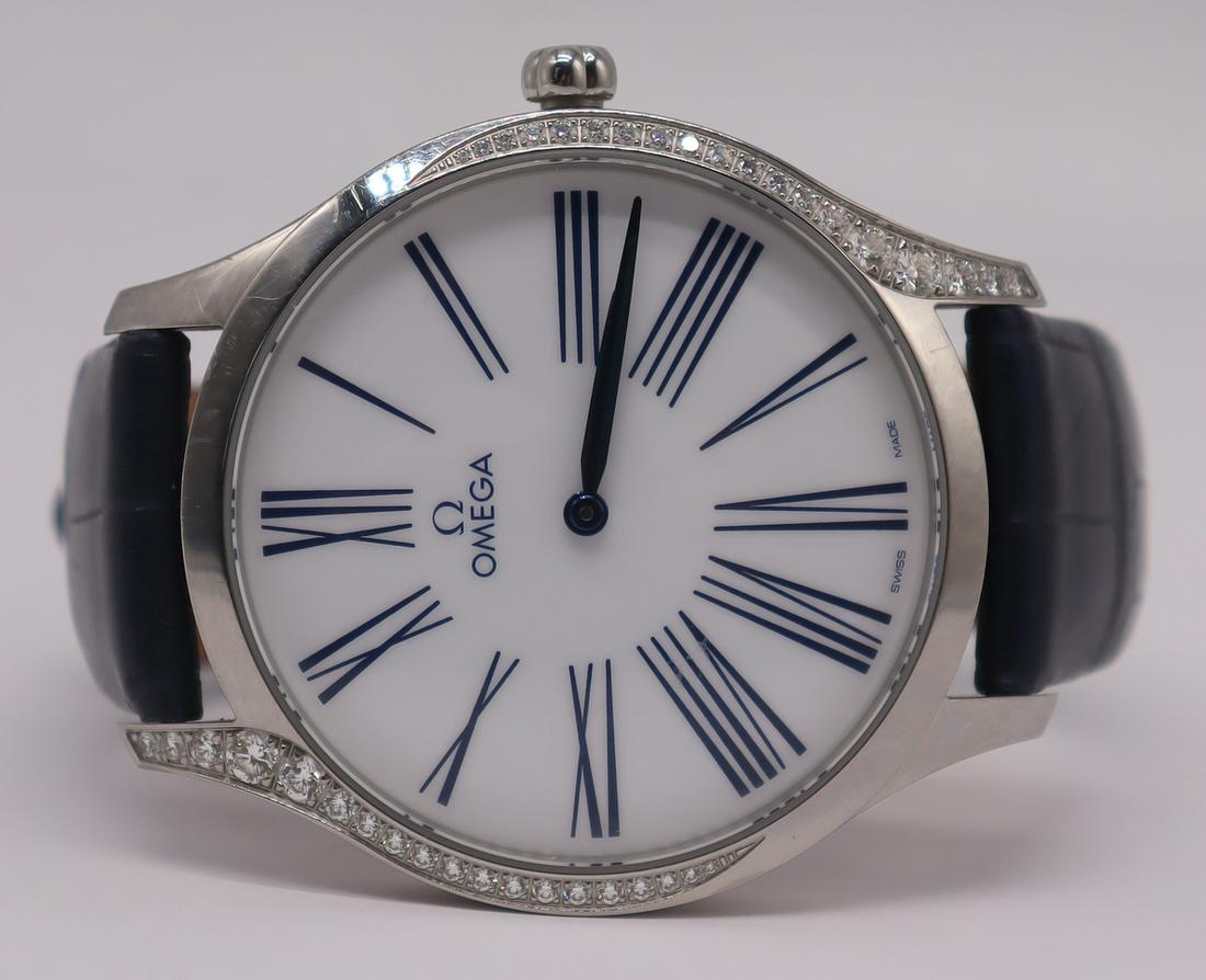 JEWELRY. Omega de Ville Tresor Watch with Diamonds: Ladies Omega de Ville Tresor stainless steel watch with pave diamond accents to bezel. Red enamel decorated floral form crown with central diamond accent. Roman numeral dial. On an Omega watch band, C