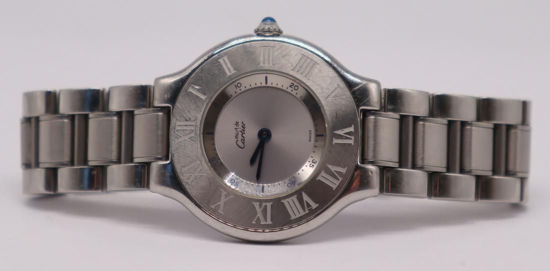 JEWELRY. Must de Cartier "21" Stainless: Must de Cartier "21" stainless steel ladies watch. Roman numerals to bezel and interior seconds dial surround. Sapphire cabochon crown. Underside of watch case stamped, "Must de Cartier 21 Swiss Made 