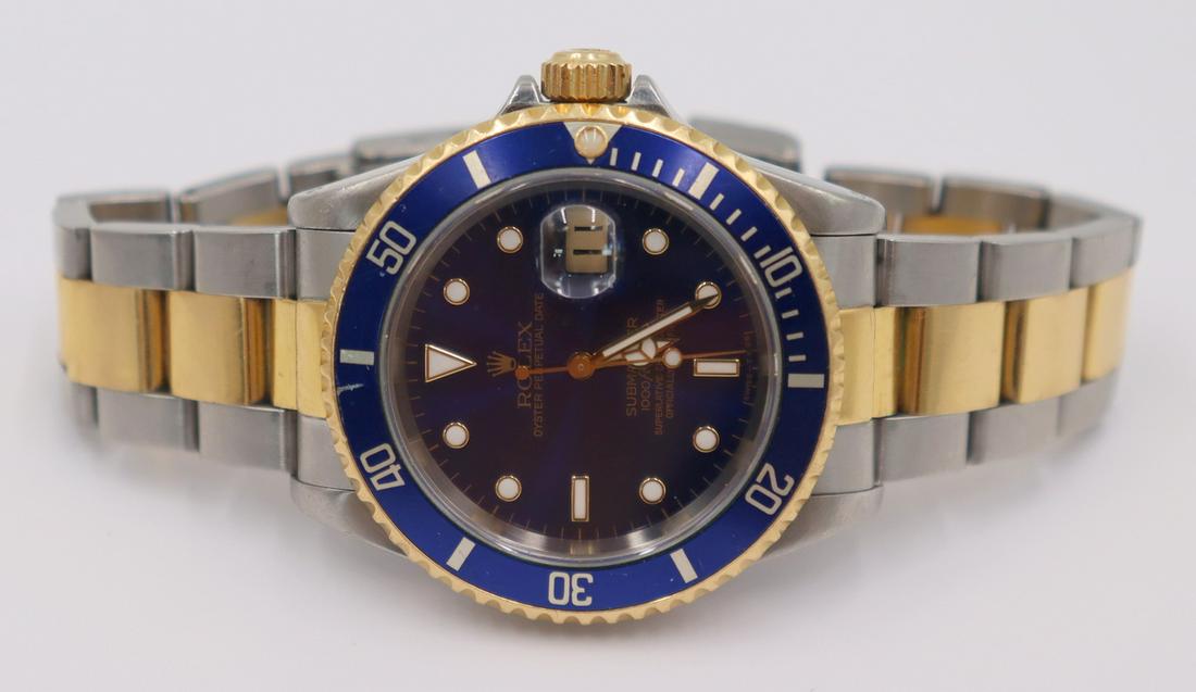 JEWELRY. Men: Men's Rolex Oyster Perpetual Submariner wrist watch with blue dial and rotating blue bezel. Watch case measures approx. 40mm. Stamped, "Orig Rolex Design 16613", and, "Stainless Steel T688249" signify