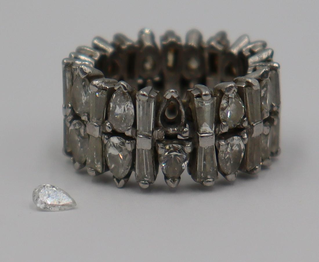 JEWELRY. Platinum and Diamond Eternity Band.: Platinum eternity band comprised of (22) pear-shaped diamonds alternating with (22) stacked tapered baguettes. One pear-shaped diamond is removed from the prong setting, but present. (22) pear-shaped 