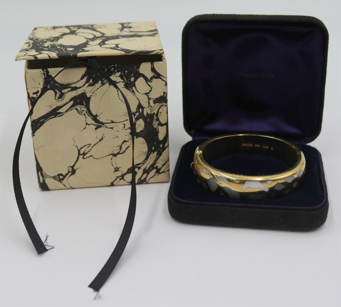 JEWELRY. Angela Cummings for T&Co 18kt Gold: Inlaid Bracelet. Angela Cummings for Tiffany & Co. 18kt yellow gold hinged bracelet with various inlaid designs to each side. Stamped to interior of bracelet, "Cummings 18kt T&Co ©&q