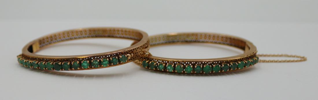 JEWELRY. Pair of 14kt Gold and Emerald Bracelets.: Pair of reticulated 14kt yellow gold hinged bracelets with central panels of (15) prong-set faceted emeralds. With safety chains - one broken. Emeralds measure approx. 3.0mm each. Apparently unmarked.