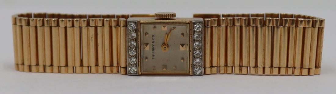 JEWELRY. Tiffany & Co. 14kt Gold and Diamond Watch: Vintage Tiffany & Co 14kt yellow gold watch with square face flanked by bands of (12) full cut diamonds. (12) diamonds measure approx. 1.5mm. Watch bracelet closure stamped, "14K C+B". C