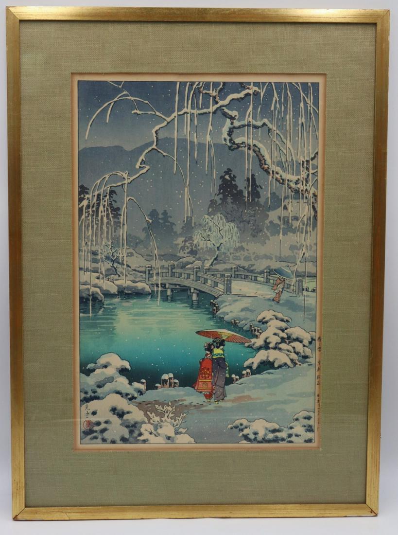 Tsuchiya Koitsu (Japanese, 1883-1957).: Signed Tsuchiya Koitsu Japanese woodblock print of a ladies walking in the snow beneath a parasol. Signed lower left with additional inscription lower right. Paper label from The Red Lantern Shop vers