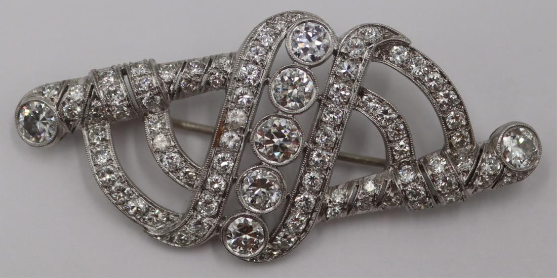 JEWELRY. Art Deco Platinum and Diamond Brooch.: Art Deco platinum brooch comprised of (7) bezel set Old European cut diamonds measuring approx. 3.5mm each and (74) full cut diamond accents measuring approx. 1.5mm each. Total approx. diamond weight 