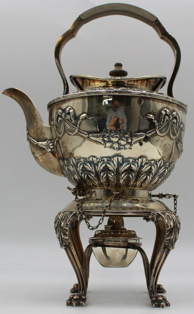 SILVER. English Silver Kettle on Stand with: Burner. An English silver kettle decorated with repousse floral swags and ribbons on a paw footed stand with cabriole legs and acanthus leaf knees. With a London city stamp, maker's mark of Carrington