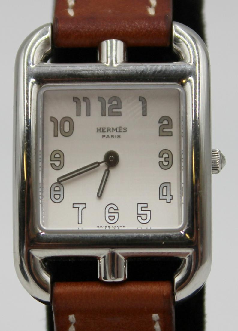 JEWELRY. Lady's Hermes Cape Cod Watch: A Lady's Hermes Cape Cod stainless quartz watch on a Hermes double-turn two-piece strap. This watch features a 23mm (excluding crown) high polished stainless case, silver tone dial, Arabic numerals, l