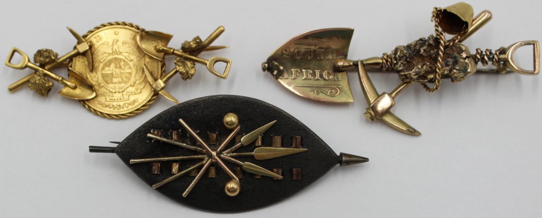 JEWELRY. (3) South African Gold and Silver: Brooches. Including a South African 9kt yellow gold brooch comprised of spade, pickaxe, bucket, and nugget - stamped, "9ct"; a 9kt yellow gold brooch with central bezel set 1894 1/2 Pond South African