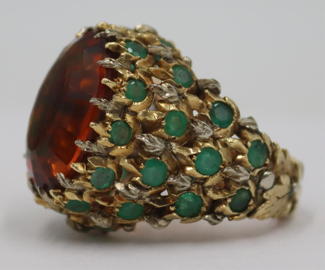 JEWELRY. Buccellati 18kt Gold and Colored Gem Ring: Signed Buccellati 18kt yellow gold statement ring with central oval faceted colored gem within a raised foliate form setting accented by (30) round faceted green gems. Center gem measures approx. 18.0