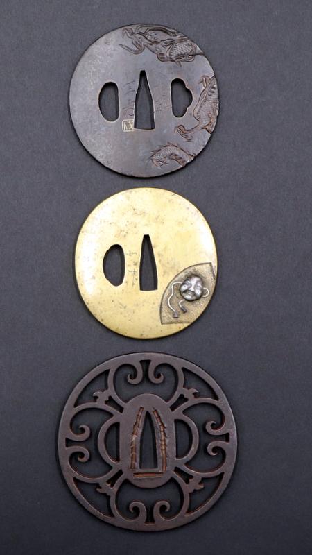 Collection of (3) Japanese Edo Period Tsubas.: A collection of (3) Edo period tsubas. Including a signed mixed metal tsuba with a silver tone Okame mask?; a signed tsuba with a single dragon spanning the reverse and obverse; and an open work tsuba