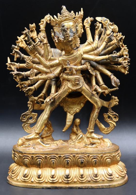 Gilt Bronze of Chakrasamvara and Vajravarahi.: Gilt bronze statue of standing figure of Chakrasamvara with (24) arms and (3) heads holding the deity Vajravarati while standing on (2) female figures. Two deities are set atop a double lotus base. Fl
