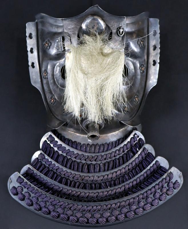 MILITARIA. Japanese Silver Menpo Tengu Menpo: Half Mask. An exceptional hand hammered Tengu menpo mask executed in silver, complete with hinged nose-piece, hinge pin lock, applied open work flower embellishments through out, external decorated as
