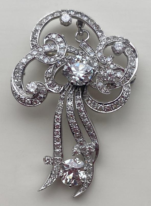 JEWELRY. (2) GIA 1.8+ ct Diamond and 18kt Gold: Brooch. Beautiful 18kt white gold ribbon form brooch or pendant displaying (2) round cut diamonds measuring 1.84cts and 1.94cts. (4) additional round brilliant cut diamonds measuring approx. 3.0mm eac
