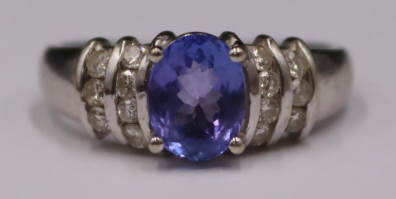 JEWELRY. Signed 14kt Gold, Tanzanite and Diamond: Ring. Signed 14kt white gold ring displaying a central prong-set oval faceted Tanzanite flanked by rows of full cut diamonds. Stamped, "CNN?" and "14k". Total approx. weight of the