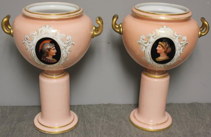 Rare Pair of 19th Century Opaline Glass Urns.: On pedestal bases. Classical style with gilded handles and portrait decoration. From a 791 Park Avenue NYC estate. Dimensions: 11" wide (including handles) x 15" h. Condition: Some worn gilding.