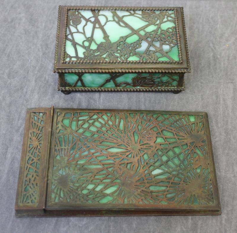 TIFFANY STUDIOS. Desk Pieces Including a Pine: Needle Note Pad Holder and a Grapevine Hinged Box. From a Yonkers, NY estate. Dimensions: Note pad - 7.25" wide x 4.5" deep x .5" high; hinged box - 5.5" wide x 3.75" deep x 1.5" high.