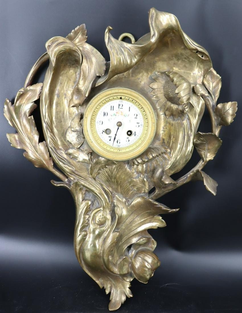 French Art Nouveau Bronze Wall Clock.: The clock with a nude woman bottom left and flowers. Two screw holes at top right, possibly something missing from clock? Reverse of movement reads "Made In France". Quite heavy. From a Hart