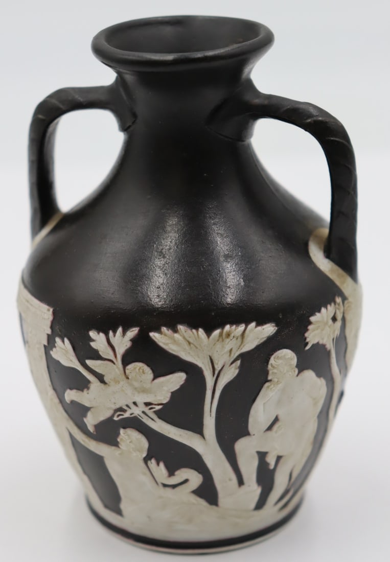 19th Century Wedgwood Black Jasper Portland Vase.: Wedgwood Black Jasper Portland Vase, the sides with applied white classical figures in relief, the underside with a relief man wearing a Phrygian cap, with an impressed mark on the bottom. From a West