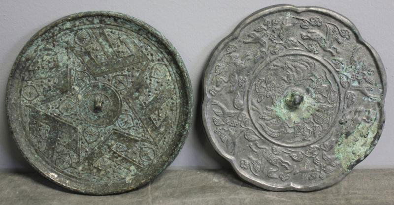 Two Small Chinese Hand Mirrors.: One with animals and shaped edge - 5.5" diameter, areas of oxidation; and the other with archaic design - 5.375" diameter, areas of oxidation. From a Rye, NY estate.