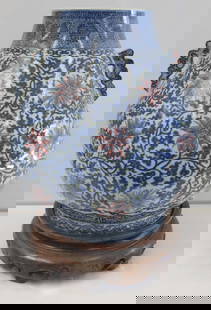 Large Chinese Blue and White Vase.: Large Chinese blue and white vase displays iron red chrysanthemums against a leafy ground. With ruyi form handles. With a Qianlong mark to the underside. Accompanied by a carved wood base. From a Gree