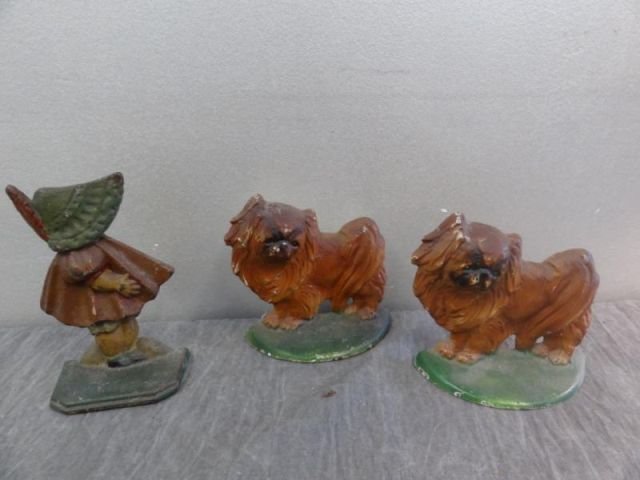 3 Vintage Iron Doorstops Including a Pair of Dogs,: and a Girl In Bonnet. From a Larchmont, NY estate. Dimensions: Dogs 5" x 5" and girl 6" x 4."