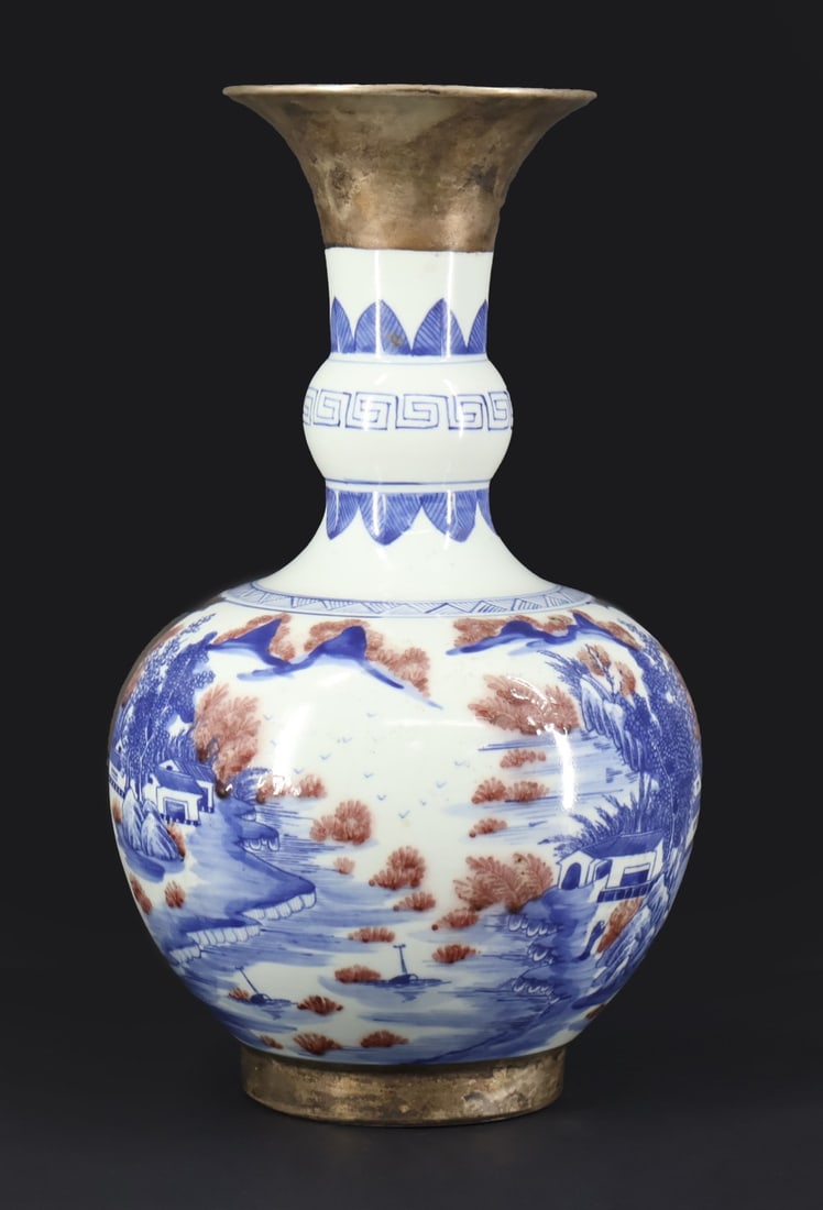 Chinese Blue and White Copper Red Vase.: A Chinese Kangxi blue and white lobed vase displaying a mountain village scene with red copper glazed vegetal accents. The rim, sides of the body, and foot exhibit a later added silver overlay. The ba