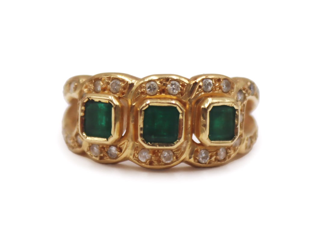 JEWELRY. 16kt Gold, Emerald and Diamond Ring.: 16kt yellow gold ring displaying (3) bezel set faceted emeralds surrounded by a total of (30) round single cut diamonds. By consignor provenance this ring was purchased in Colombia. Total approx. weig